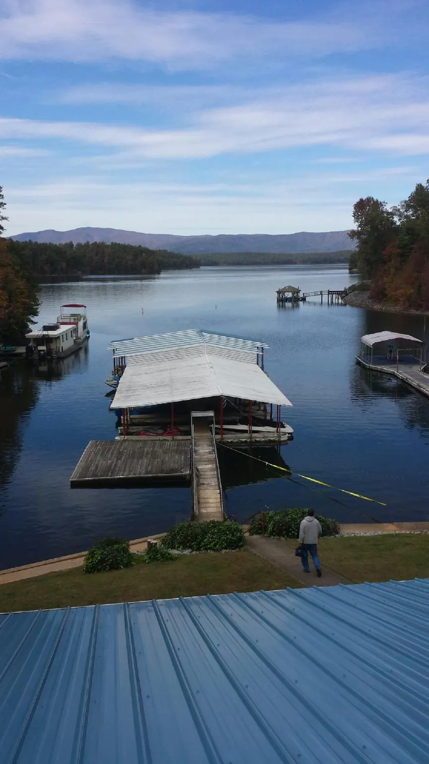 View across a lake from a newly installed blue metal roof in Keyes