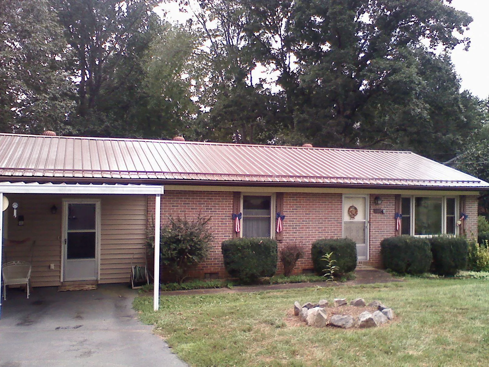 Bronze metal roof and carport on a brick ranch home — Roof Repair work by our crew in Keyes