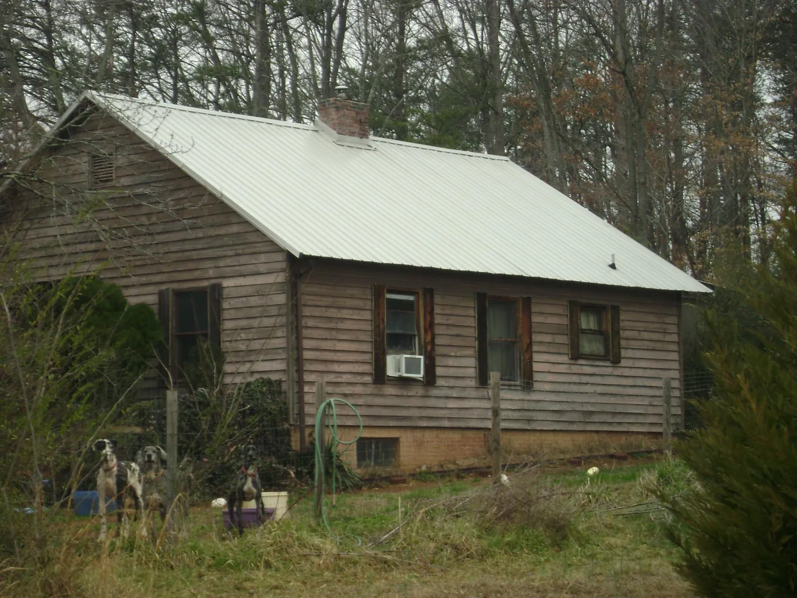 White metal roof on an old wood sided farmhouse, from a Metal Roof Installation job in Keyes